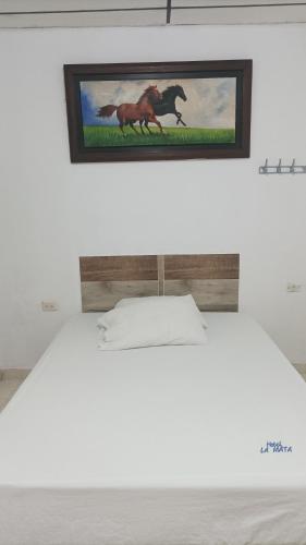 una foto de un caballo en la pared sobre una cama en Hotel La Mata 
