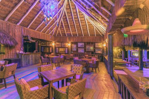 a restaurant with tables and chairs and a ceiling at Embajada Universal By La Eufemia Group in Huay Pix