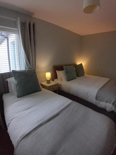 two beds sitting in a room with a window at Fairwinds Guest Accommodation in Doolin