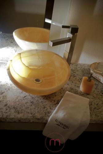 a bathroom sink with a wooden bowl on a counter at La Moraleja Love hotel in Mexico City