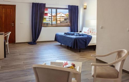 a room with a bed and a table and a chair at Hotel LIVVO Budha Beach in Santa Maria