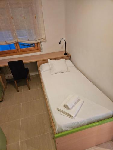 阿爾卡尼斯的住宿－MEQUEDO CALLE MAYOR 18，一张小床,位于带桌子和椅子的房间里