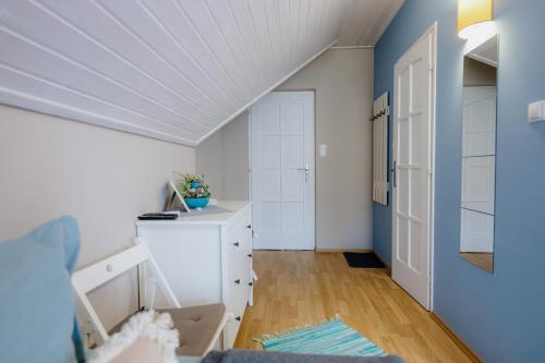 a room with a white cabinet and a blue wall at Pihi Vendégház in Badacsonytomaj