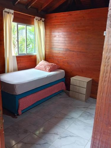 a small bedroom with a bed and a window at Sharick Beach House in Tubará