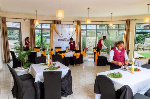 a restaurant with two tables with people serving food at One Click Hotel in Kigali
