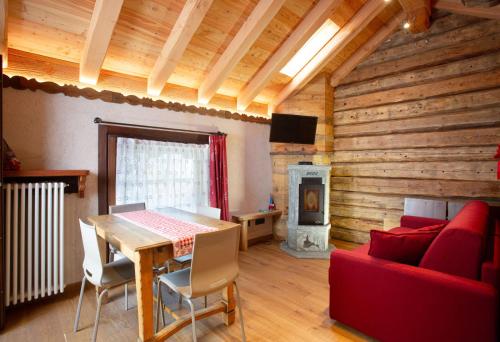 Una sala de estar con una mesa y una chimenea. en Casa Girod - Rascard, en Issime