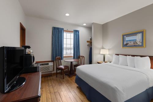 a hotel room with a bed and a television at Days Inn by Wyndham Kill Devil Hills Oceanfront - Wilbur in Kill Devil Hills