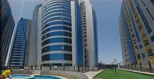 a large building with a pool in front of it at orient 1 BHK APARTMENT in Ajman 