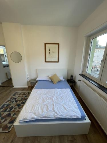 ein Schlafzimmer mit einem Bett in einem Zimmer mit einem Fenster in der Unterkunft 3-Zimmer-Wohnung / 10min vom ICE in Siegburg