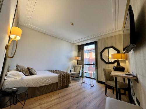 a hotel room with a bed and a desk at Hotel Bahía in Santander
