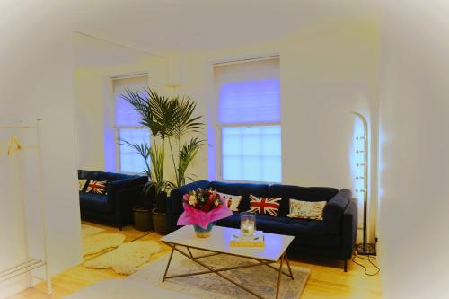 a living room with a blue couch and a table at Cosy Stay Soho London in London