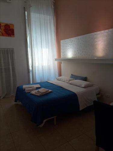 a bedroom with a large bed with a blue blanket at H Central Lecce in Lecce