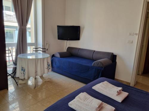 a living room with a blue couch and a table at H Central Lecce in Lecce