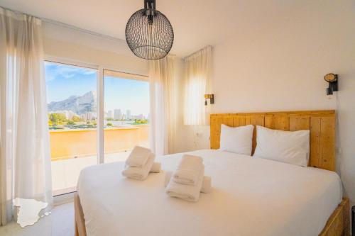sypialnia z białym łóżkiem i dużym oknem w obiekcie CostaBlancaDreams Casa Colari 4 in Calpe w mieście Calpe