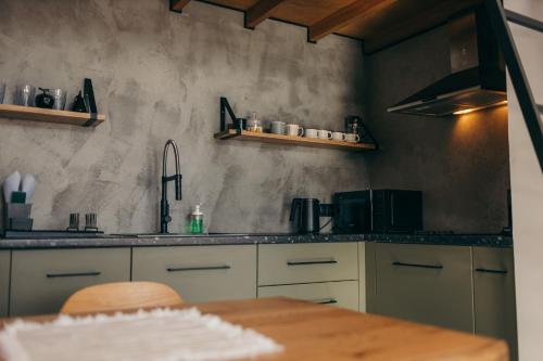 uma cozinha com uma mesa de madeira e um lavatório em Travy em Tatariv