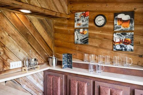 a bar with glasses and a clock on the wall at Large home with indoor heated pool! 