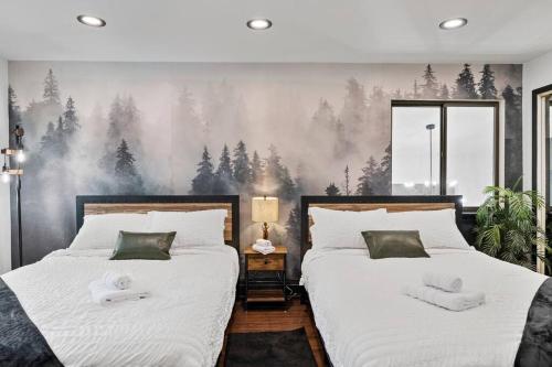 two beds in a bedroom with a forest mural at Large home with indoor heated pool! 