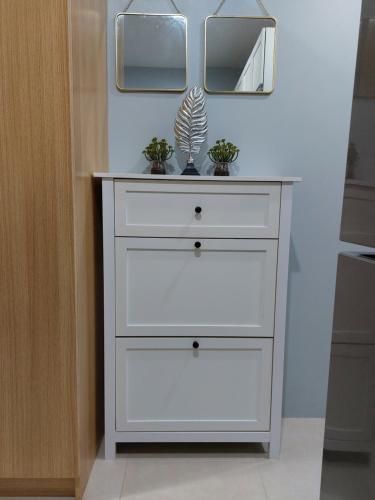 a white dresser with two mirrors on top of it at Cozy Apartment in Cebu IT Park T2517 in Cebu City