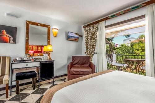 a bedroom with a bed and a desk and a chair at Boutique Hotel Las Islas in Fuengirola