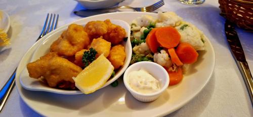 a plate of food with chicken and vegetables on a table at Enniskeen Country House Hotel in Newcastle