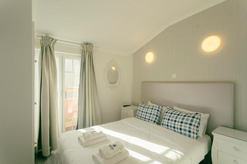 a bedroom with a white bed with two towels on it at Best Houses Portugal Residence in Peniche