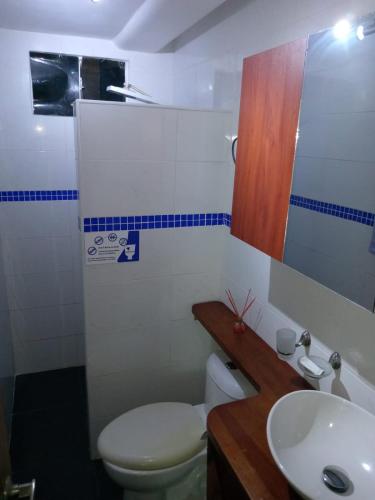 a bathroom with a toilet and a sink at Sharick Beach House in Tubará