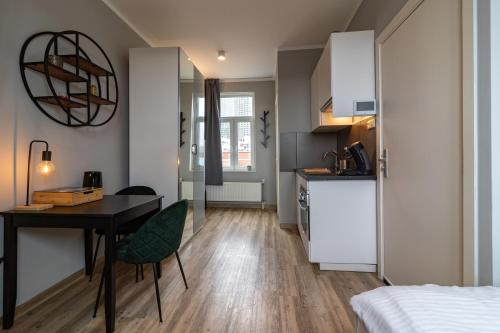 a small apartment with a desk and a kitchen at Homey Studios - City Centre in The Hague