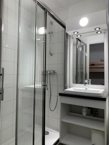 une salle de bain avec une douche en verre et un lavabo dans l'établissement travelski home classic - Résidence La Muzelle, à Les Deux Alpes