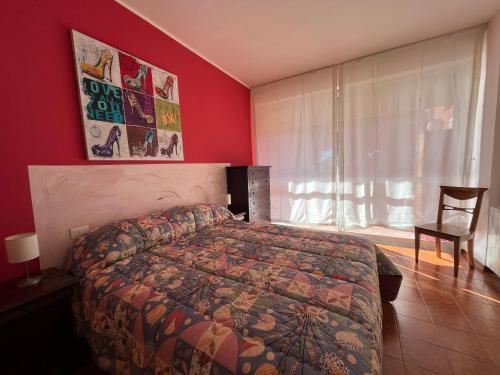 a bedroom with a bed and a red wall at Appartamento Fiore in Follonica