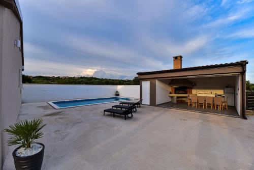 a patio with a table and chairs and a swimming pool at Villa Laura in Nadin