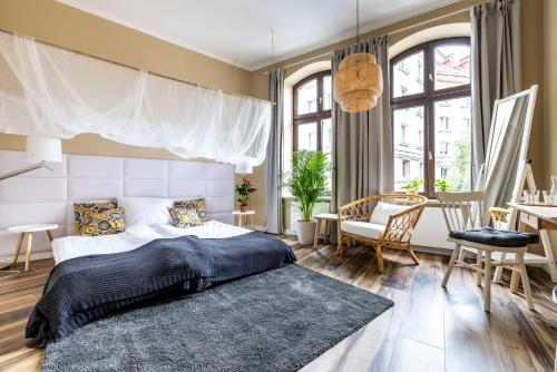 a bedroom with a large bed and a dining room at Cichy Zakątek Apartamenty przy Starym Rynku in Poznań