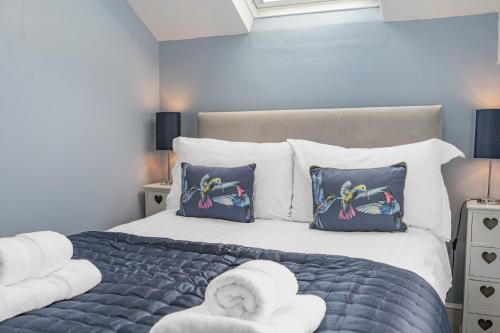 a bedroom with a large bed with towels and pillows at The Apartments Coniston in Coniston