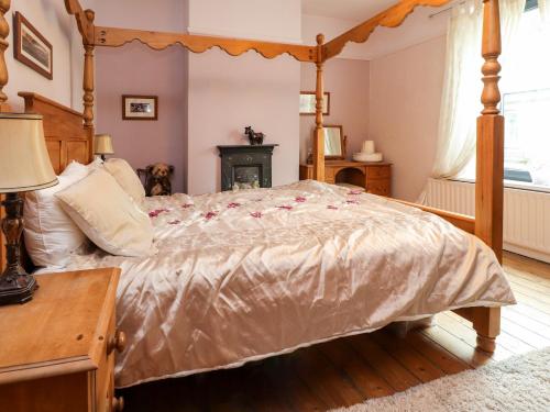 a bedroom with a canopy bed with roses on it at Ribble Valley Cottage in Preston