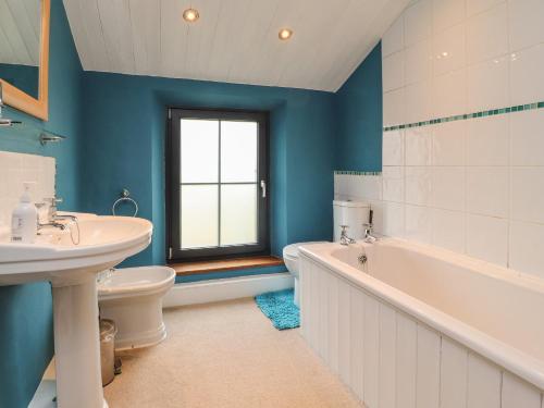 a bathroom with a tub and a toilet and a sink at Ribble Valley Cottage in Preston