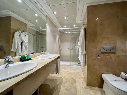 a bathroom with two sinks and a shower at Hotel Bahía in Santander