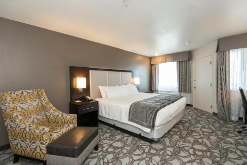 ポルソンにあるKwataqnuk Resort & Casinoのベッドと椅子付きのホテルルーム