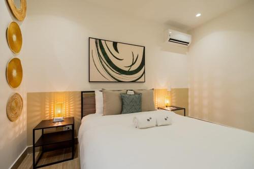 una camera da letto con un grande letto bianco e due comodini di Captivating 1BR in Casco Viejo a Città di Panama