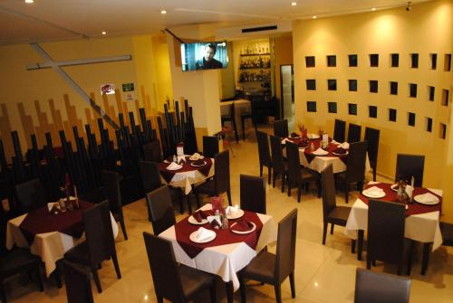 a dining room with tables and chairs and a tv at La Moraleja Love hotel in Mexico City