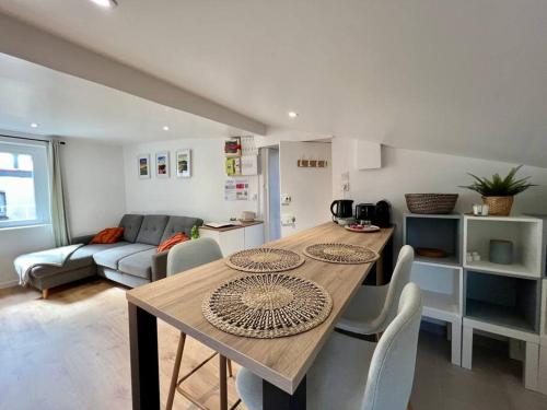 Il dispose d'une cuisine et d'un salon avec une table et des chaises en bois. dans l'établissement F2 *La Treille* Centre Historique Clermont FD 3p, à Clermont-Ferrand