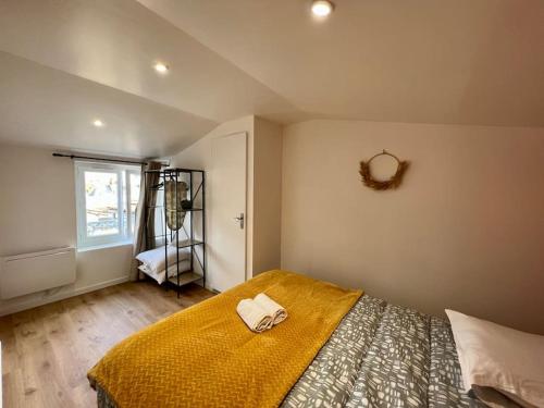 - une chambre avec un lit doté d'une couverture jaune et d'une fenêtre dans l'établissement F2 *La Treille* Centre Historique Clermont FD 3p, à Clermont-Ferrand