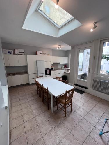 een keuken met een tafel en stoelen en een dakraam bij Grande maison avec 5 chambres in Saint-Omer