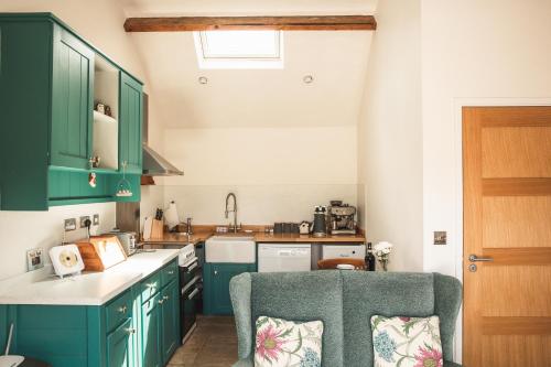 une cuisine avec des placards verts et une chaise dans l'établissement Hootsman, à Rosedale Abbey