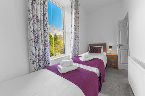 a bedroom with two beds and a window at The Apartments Coniston in Coniston