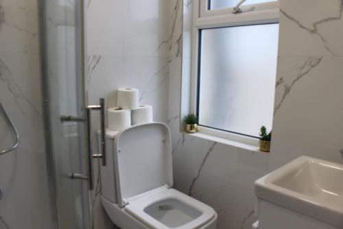 a bathroom with a toilet and a sink and a window at BrAnD NeW StuNNing Studio FlaT! in London