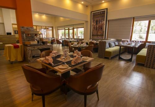 a restaurant with tables and chairs in a room at Thimphu Deluxe Hotel in Thimphu