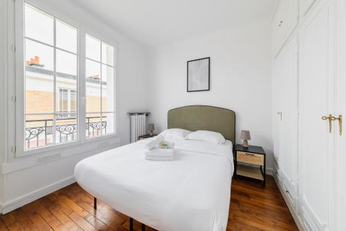 Un dormitorio con una gran cama blanca y una ventana en Cosy 2 pieces proche metro - Paris 13 - 4P, en París