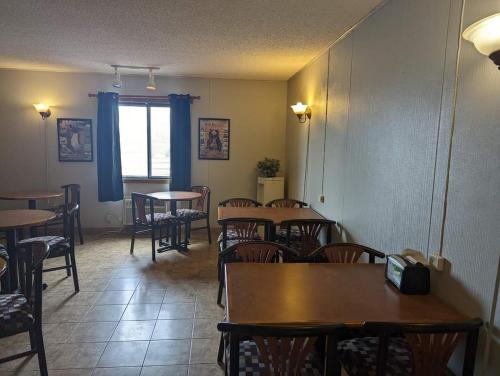 ein Esszimmer mit Tischen, Stühlen und einem Fenster in der Unterkunft Beartooth Inn in Cody