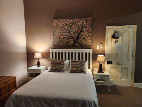 a bedroom with a large white bed with two lamps at Spes Bona guesthouse in Colesberg