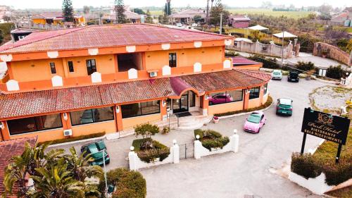 un bâtiment orange avec des voitures garées dans un parking dans l'établissement Park Hotel, à Casa Francesi