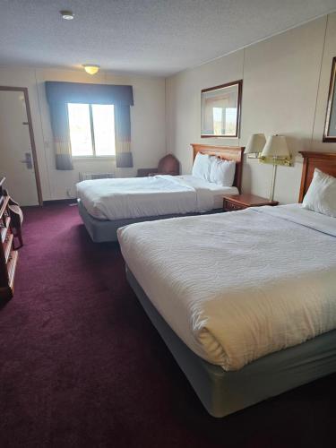um quarto de hotel com duas camas e um sofá em Beartooth Inn em Cody